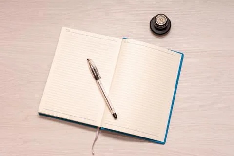 Opened notebook with black pen and official stamp on a white wooden table, to Foto stock