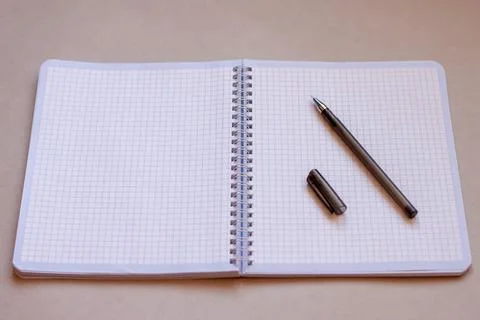 Opened notebook in a cage on a spiral and a black handle Stock Photos