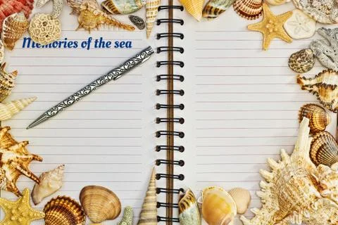 Opened notebook with a pen framed with sea shells Stock Photos