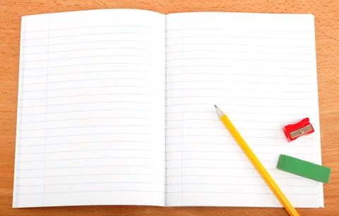 An opened notebook, pencil and stationery on a wooden table. Stock Photos