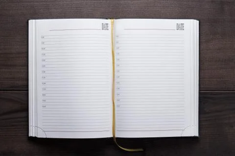 Opened notebook on the wooden table Stock Photos