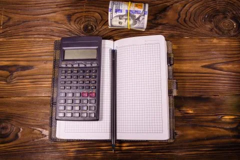 Opened notepad, one hundred dollar banknotes, scientific calculator Stock Photos