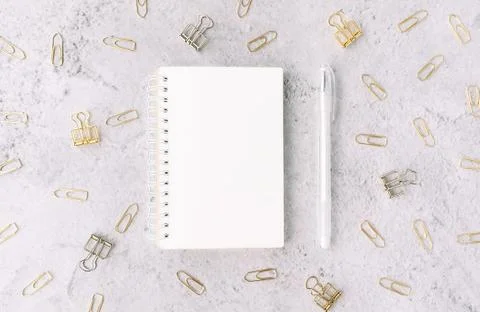 Opened notepad with white pen on background with set of silver and gold paper Stock Photos