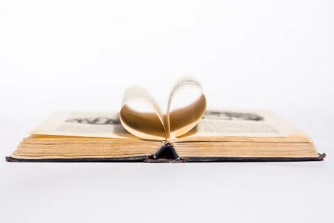 Opened old book with pages in form of heart on the white background Stock Photos