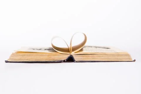 Opened old book with pages in form of heart on the white background Stock Photos