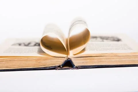 Opened old book with pages in form of heart on the white background Stock Photos