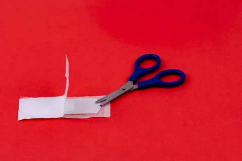 Opened pavement with blue scissors on red background - first aid Stock Photos