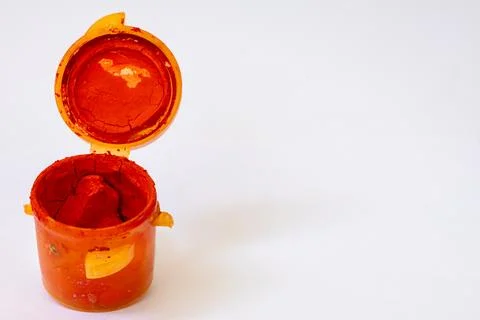 Opened plastic jar with red dry gouache paint Fotos de archivo