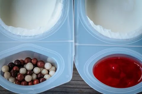 Opened plastic snack package with white yogurt. Fotos Stock