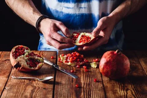 Opened Pomegranate Fruit in Hands Stock Photos