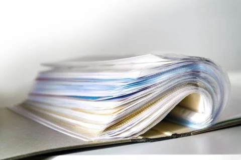 Opened ring binder with a lot of documents in transparent sleeves or punch... Stock Photos