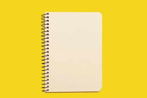 Opened spiral notebook on a yellow surface Stock Photos