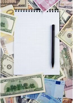 Opened spiral notepad  on money background.  with black pen 스톡 사진