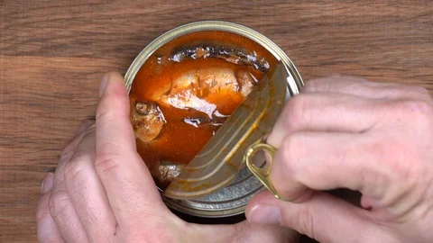 Opened tin can of sprats fish, sardines in tomato sauce. Top view, close up Stock Footage 93535574