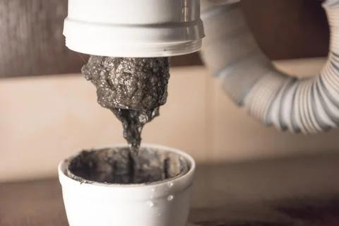 Opened the trap, which was clogged. There is a lot of dirt and black algae in Stock Photos