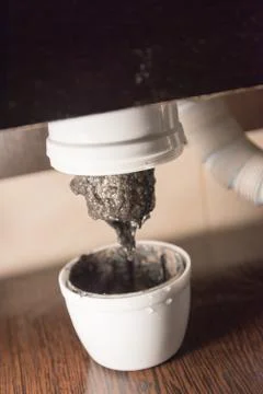 Opened the trap, which was clogged. There is a lot of dirt and black algae in Stock Photos