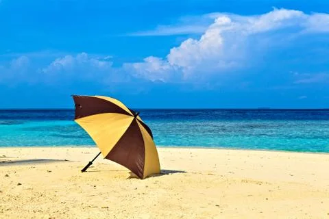 Opened umbrella is on the ocean beach 스톡 사진