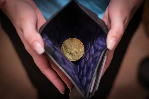 In an opened wallet there is one bitcoin coin Stock Photos