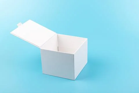 Opened white paper cube box on a blue background. 库存照片
