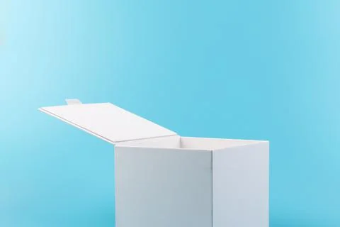 Opened white paper cube box on a blue background. Stock Photos