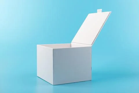 Opened white paper cube box on a blue background. Stock Photos