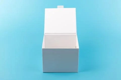 Opened white paper cube box on a blue background. Stock Photos