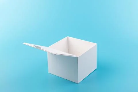 Opened white paper cube box on a blue background. Foto stock