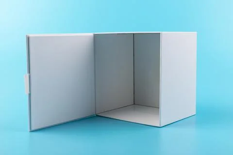 Opened white paper cube box on a blue background. Stock Photos