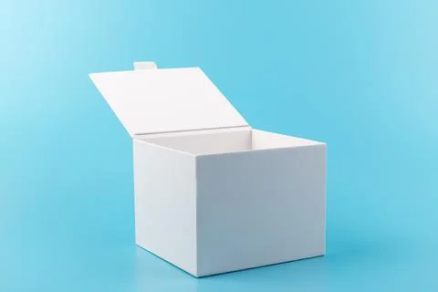 Opened white paper cube box on a blue background. Stock Photos