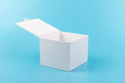 Opened white paper cube box on a blue background. Stock Photos