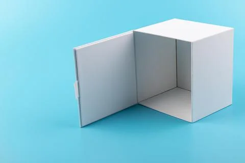 Opened white paper cube box on a blue background. Stock Photos
