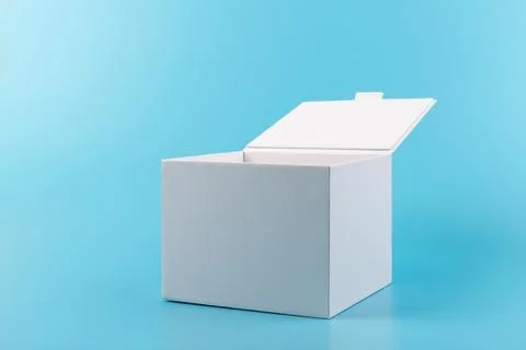 Opened white paper cube box on a blue background. Stock Photos