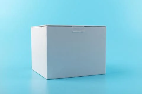 Opened white paper cube box on a blue background. Stock Photos