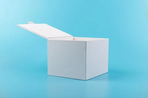 Opened white paper cube box on a blue background. Stock Photos