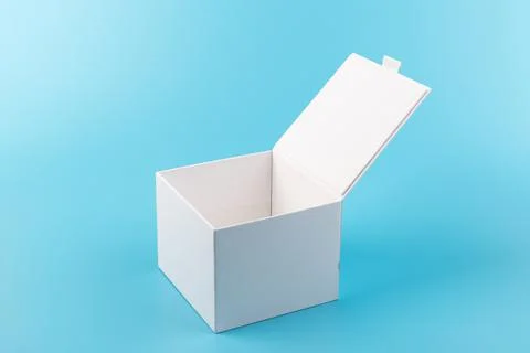 Opened white paper cube box on a blue background. Stock Photos