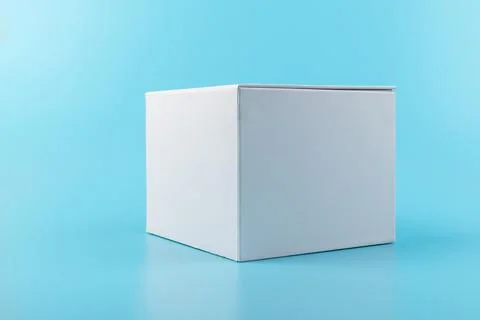 Opened white paper cube box on a blue background. Stock Photos