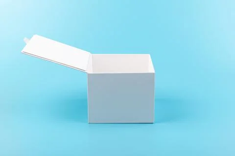 Opened white paper cube box on a blue background. Stock Photos