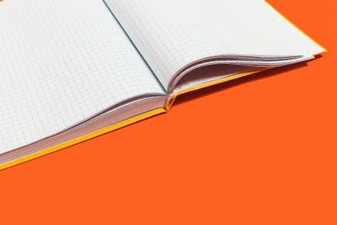 Opened workbook on an orange surface Stock Photos