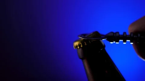 Opener opens a cap of the bottle of dark beer Stock Footage 129651876