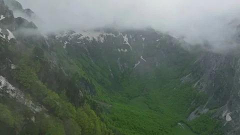 Opening aerial view fly through forest and clouds to mountain valley Video stock 249999968
