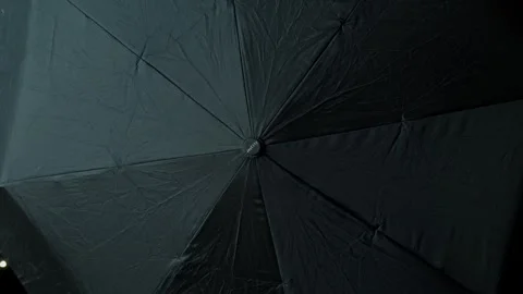 Opening and closing a black umbrella from rain on the roof Stock Footage 312077635