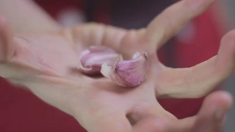 Opening and closing hand with 2 cloves of garlic Stock Footage 75584726