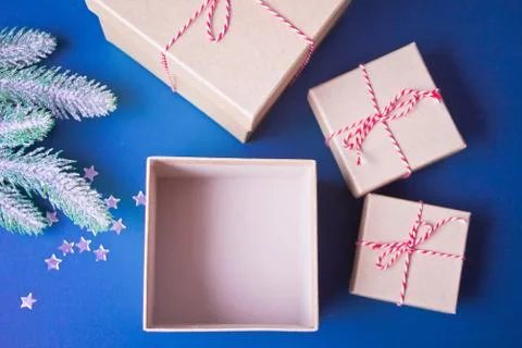 Opening and empty Christmas gift boxes on the blue background with pine branc 库存照片