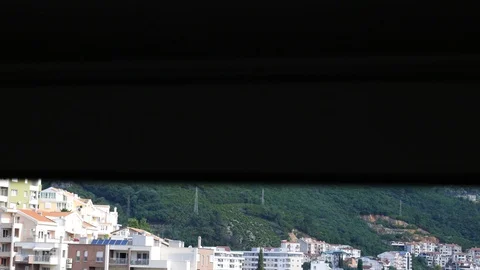 Opening automatic shutters. View of the mountains and the city below Video stock 112946304