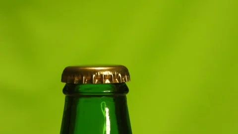 Opening a bottle on a green background with a bottle opener. Stock Footage 255987751