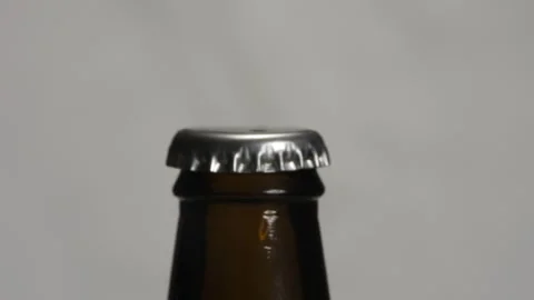 Opening a bottle on a white background with a bottle opener. Stock Footage 255987725