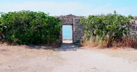 An opening in the boundary wall with limestone blocks which leads to a cliff Vídeo Stock 154630970