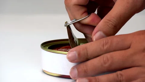 Opening a can of meat with a gold cap and a white background and hard to open Stock Footage 314460132