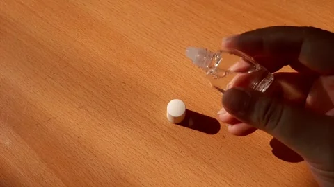 Opening the cap of an eye drop bottle and dropping it Stock Footage 284441552