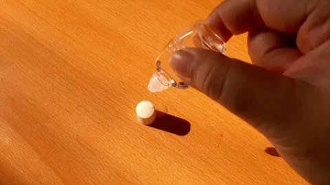 Opening the cap of an eye drop bottle and dropping it Stock Footage 284441623